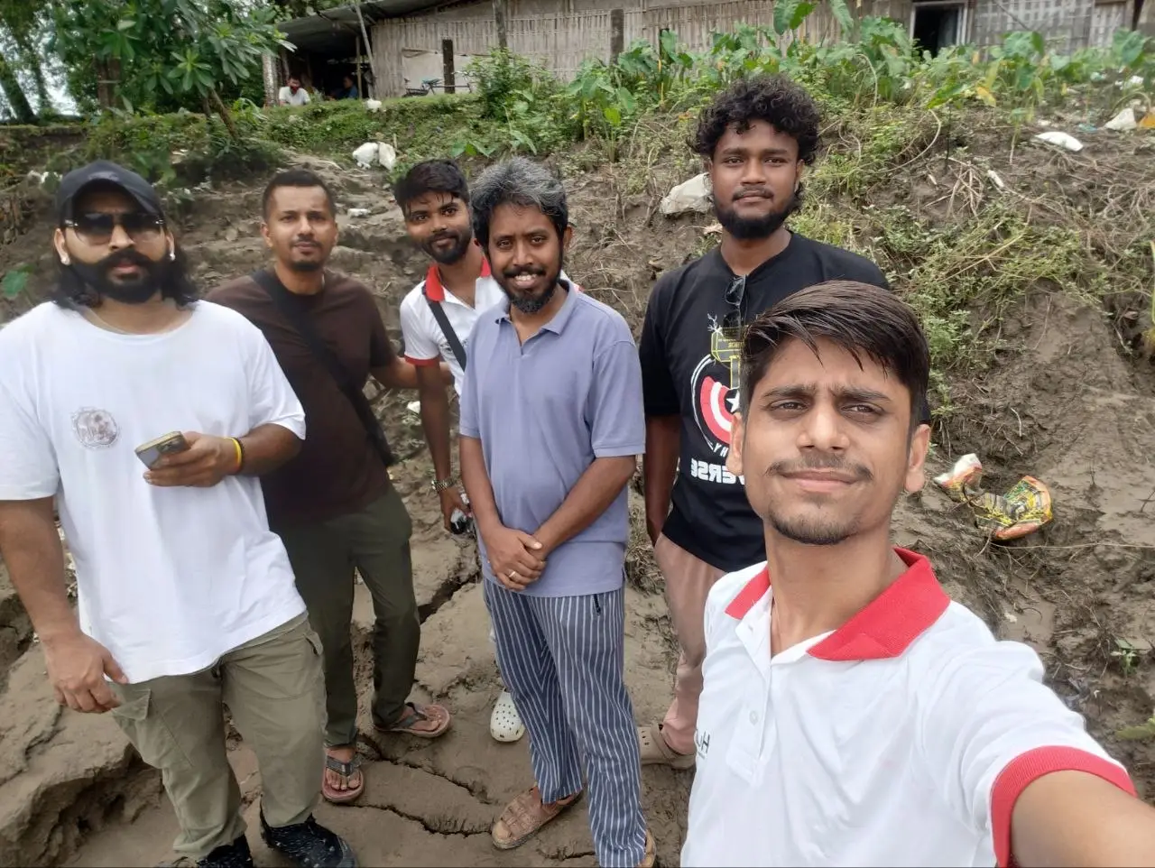 Five Humrahi volunteers photographed together on the scoured, mud-caked river bank