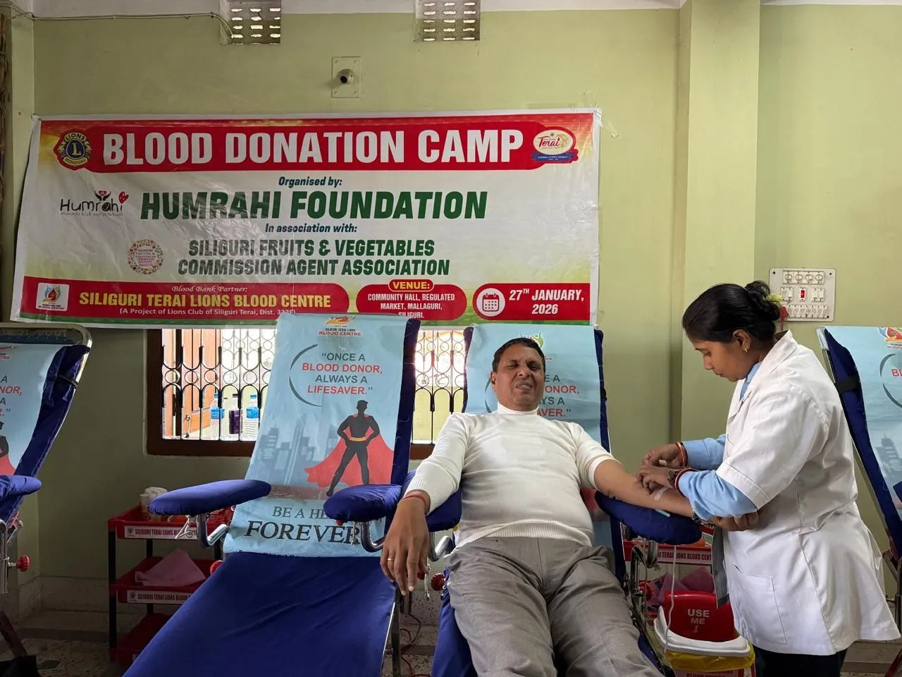 A donor giving blood with a nurse attending at a Humrahi blood donation camp