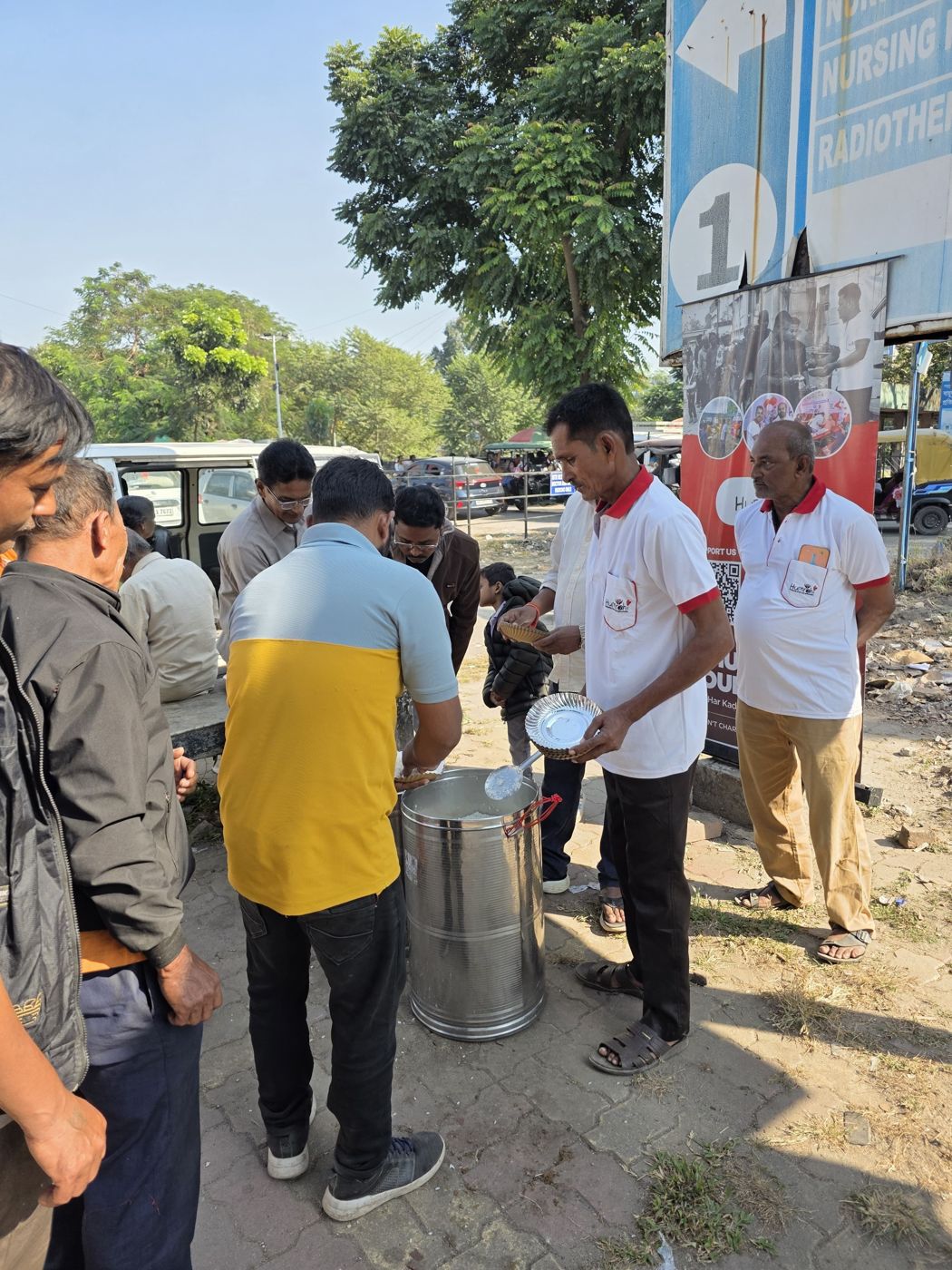 A long line of people being served warm meals outside a Siliguri hospital