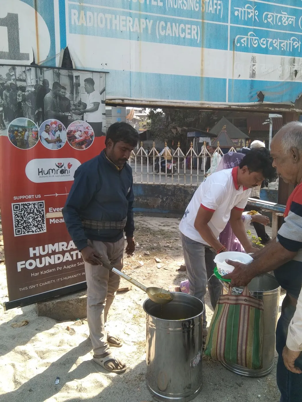 A Humrahi volunteer serving food to people queued at a distribution point in Siliguri