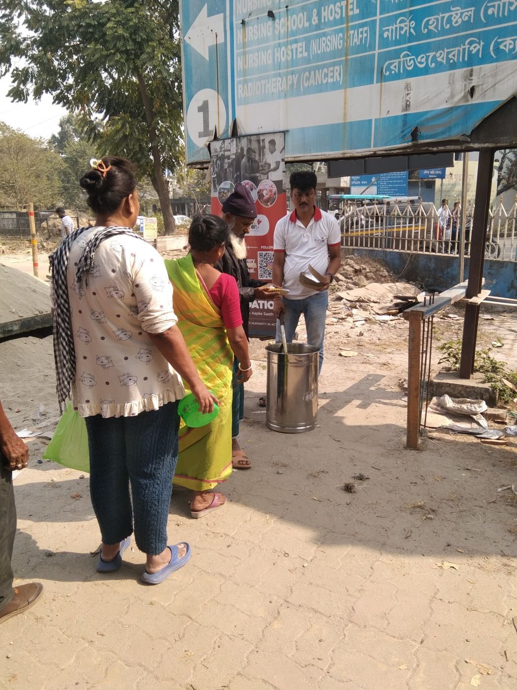 Steel plates being filled with hot food during a Humrahi food run