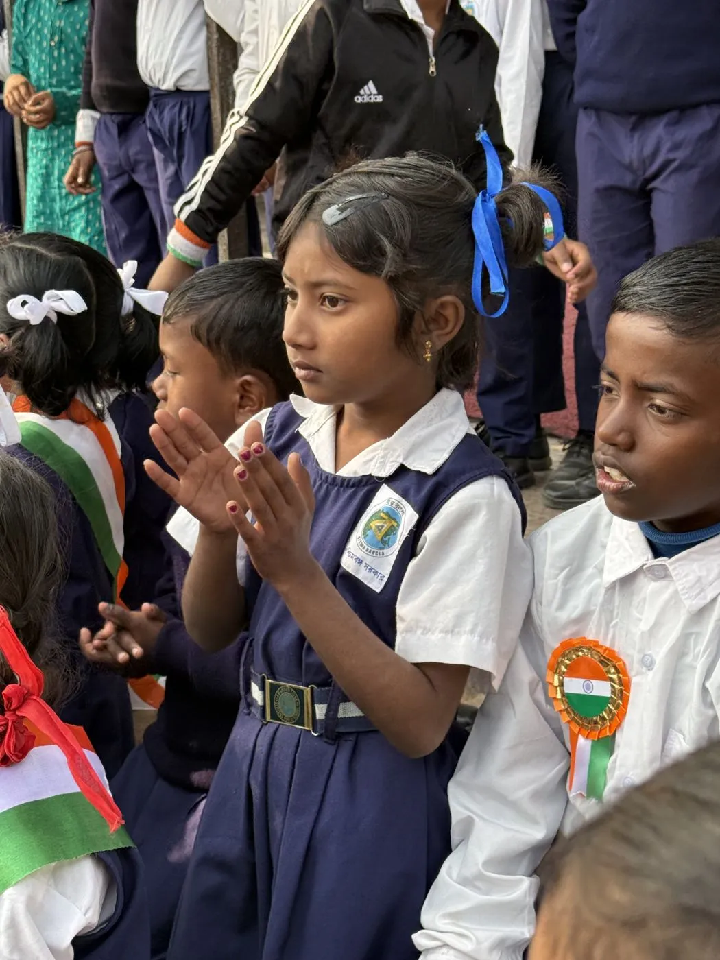 A student clapping during an assembly at an adopted school