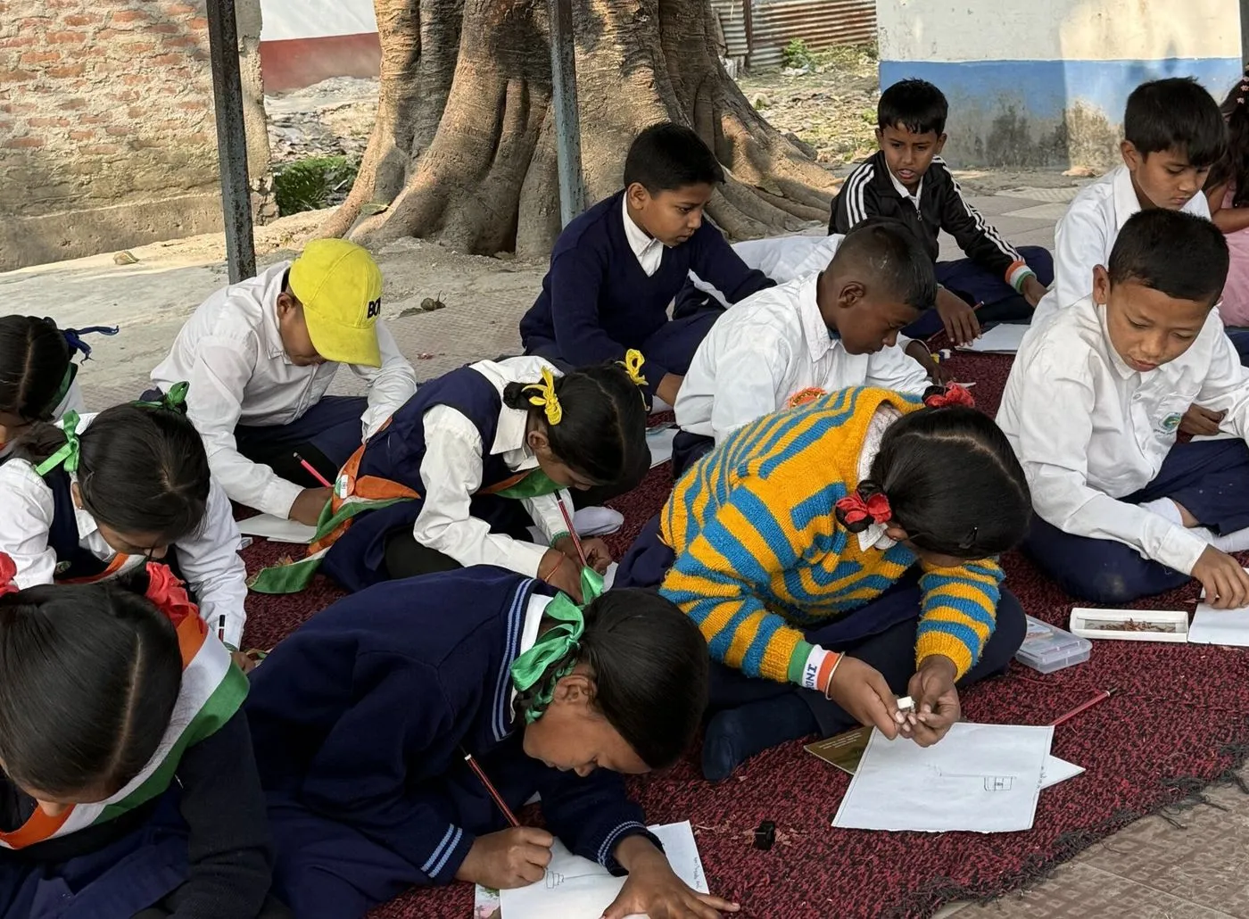 Children drawing together on mats at a Humrahi kids' drawing competition